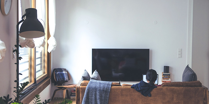 WLAN Router richtig platzieren: Frau mit Laptop im Wohnzimmer