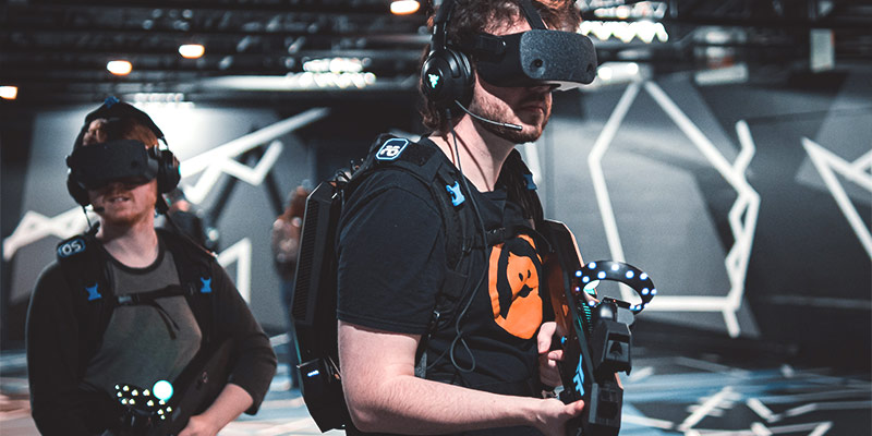 VR und Gaming: zwei Gamer mit VR-Headsets und VR-Waffen beim Gamen