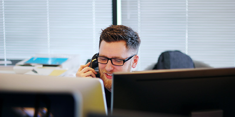 Telefonielösung für KMU: Mann telefoniert im Büro mit Telefon