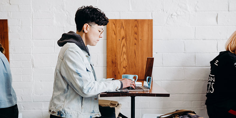 Multi-SIM: Frau mit Laptop und Handy in Café